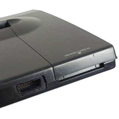 Close-up of a black gaming console with memory card slot on a white background